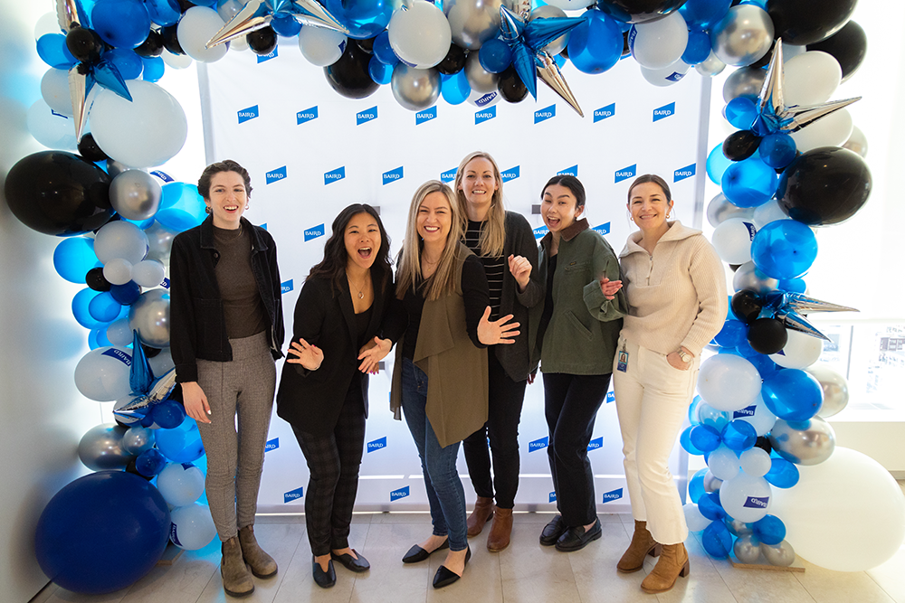 Group of SilverPeak Strategic Capital Associates standing as a group under a balloon arch.