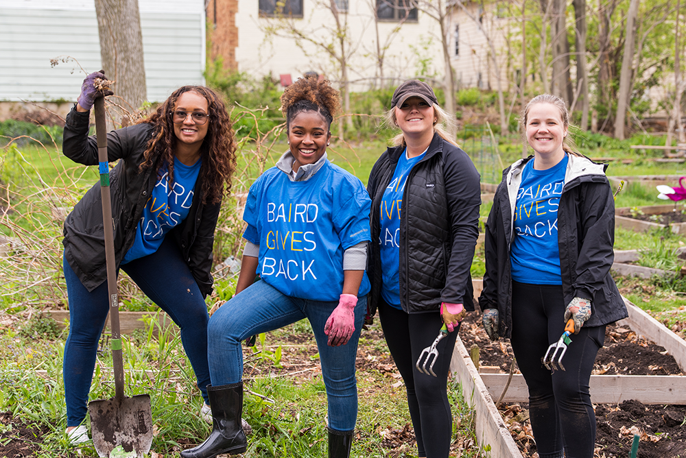 Four SilverPeak Strategic Capital associates working in an outdoor garden while volunteering.